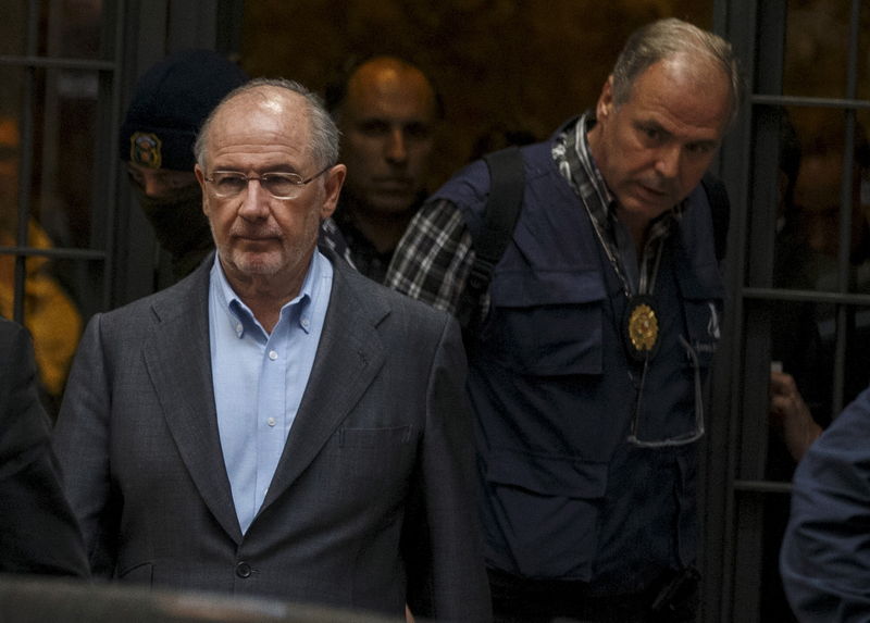 © Reuters. Rato, former People's Party minister and former managing director of the International Monetary Fund, is lead by police as they leave his residence after an inspection in Madrid