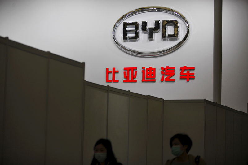 © Reuters. File photo of women walking past the logo of Chinese car manufacturer BYD Auto stage before the 15th Shanghai International Automobile Industry Exhibition