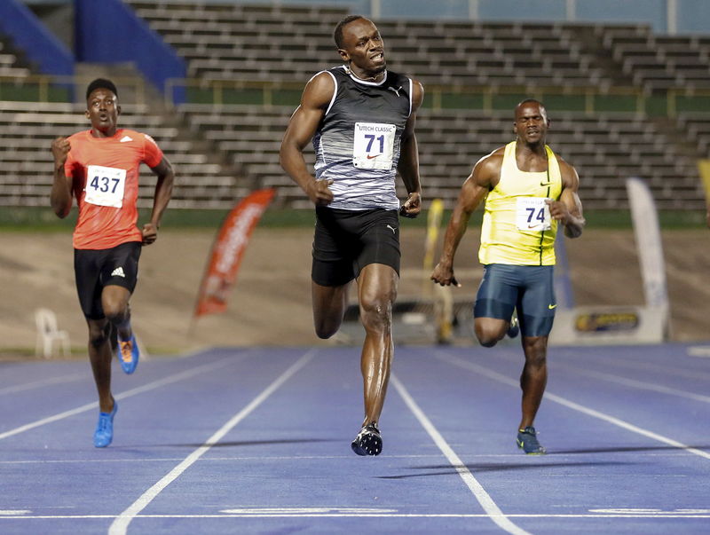 © Reuters. Bolt crosses the finish line first to win his first 200m race for the season with a time of 20.20 seconds next to Francis and Carter during the UTECH Classic 2015 at the National Stadium in Kingston