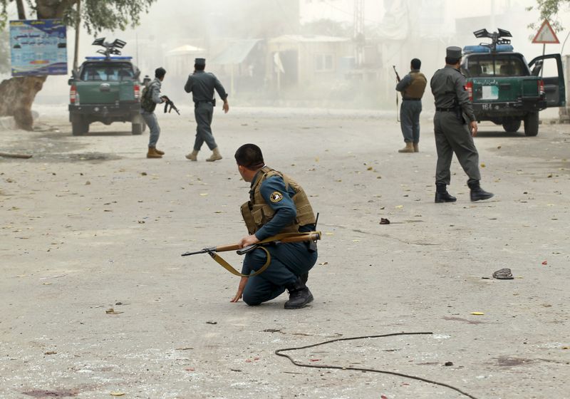 © Reuters. Policemen keep watch at a site after a third explosion in Jalalabad