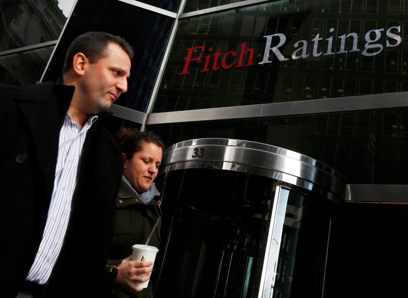 © Reuters. People walk past the headquarters of Fitch Ratings in New York