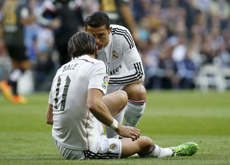 © Reuters. Real Madrid's Cristiano Ronaldo talks to his teammate Gareth Bale after an injury during their Spanish First Division soccer match against Malaga at Santiago Bernabeu stadium in Madrid