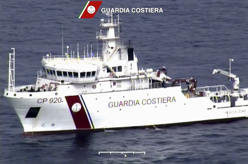 © Reuters. An Italian coast guard vessel is seen during the search and rescue operation underway after a boat carrying migrants capsized overnight, with up to 700 feared dead, in this still image taken from video