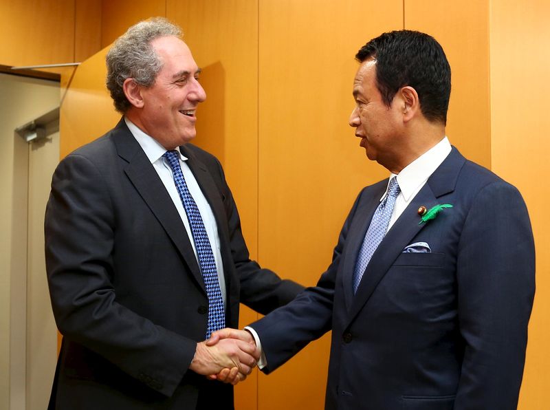 © Reuters. Japan's Economics Minister Amari shakes hands with U.S. Trade Representative Froman ahead of their meeting in Tokyo