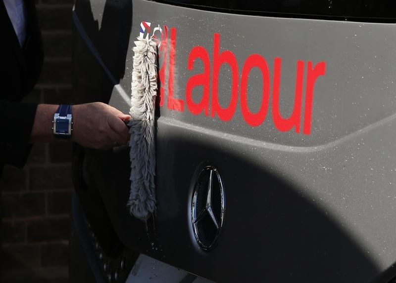 © Reuters. The driver cleans the front of Britain's Labour Party leader Ed Miliband's battle bus at a campaign event in Pensby northern England