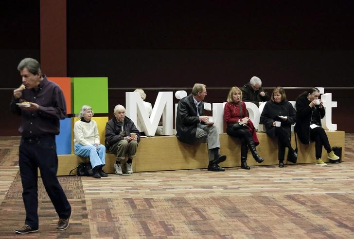 © Reuters. Microsoft Corp shareholders drink coffee as they wait to hear Chief Executive Satya Nadella speak at his first annual shareholders' meeting in Bellevue, Washington