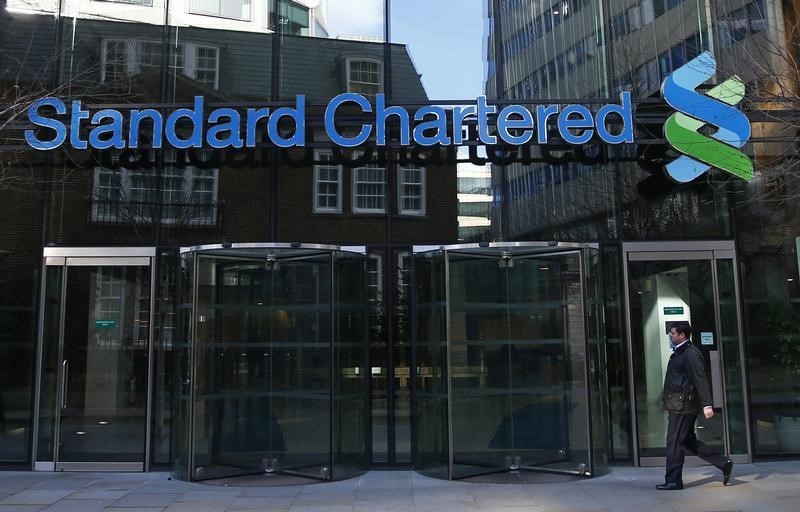 © Reuters. A man walks past the head office of Standard Chartered bank in the City of London