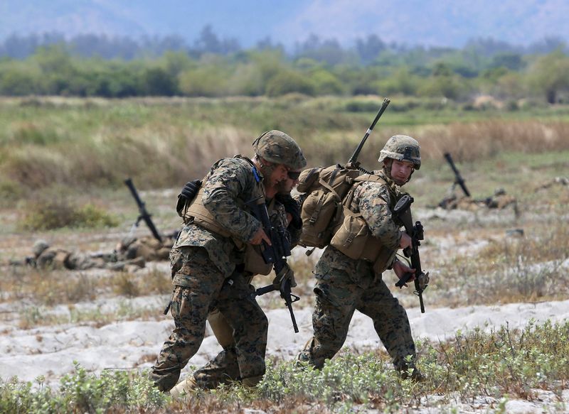 © Reuters. U.S. soldiers help an injured colleague during the annual "Balikatan" war games with Filipino soldiers on the shore of San Antonio