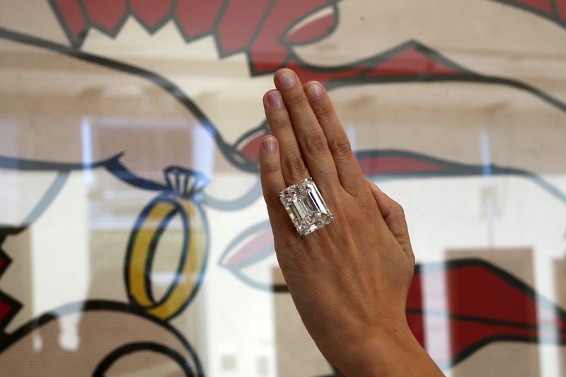 © Reuters. Modelo apresenta o anel com diamante de 100,2 quilates em frente ao quadro "The Ring" de 1962 de Lichtenstein em evento pré-leilão da Sotherby's em Los Angeles. 