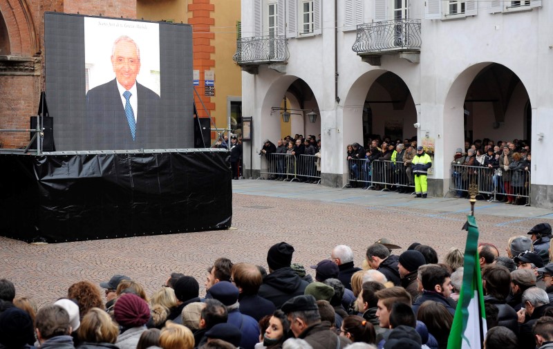 © Reuters. A picture of Michele Ferrero is displayed on a giant screen as people gather to pay respect during the funeral service in Alba