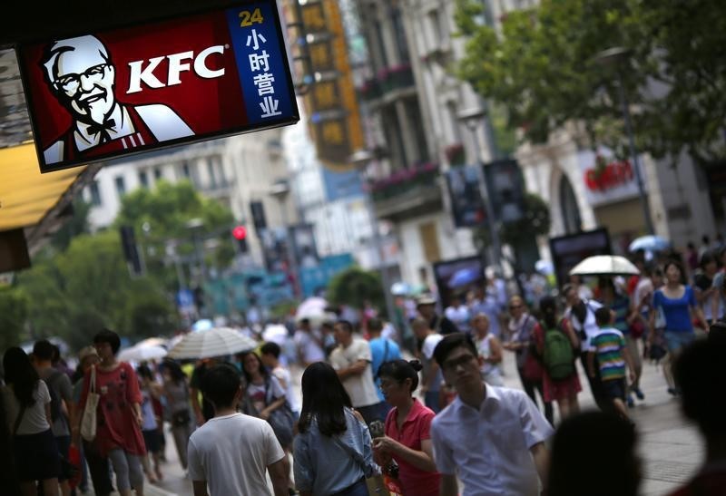 © Reuters. People walk past a KFC store in downtown Shanghai