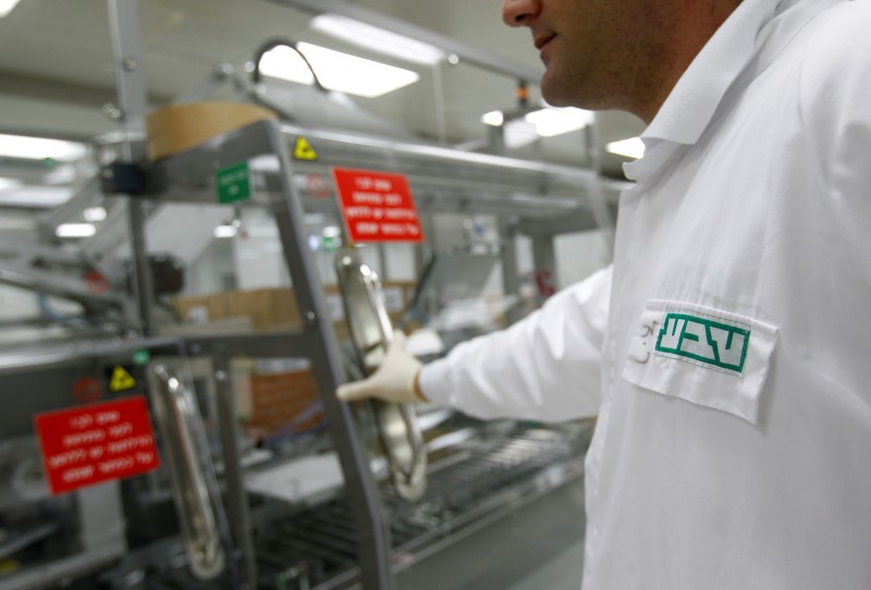 © Reuters. An employee of Teva wears a shirt bearing the company's logo  at Jerusalem oral solid dosage plant