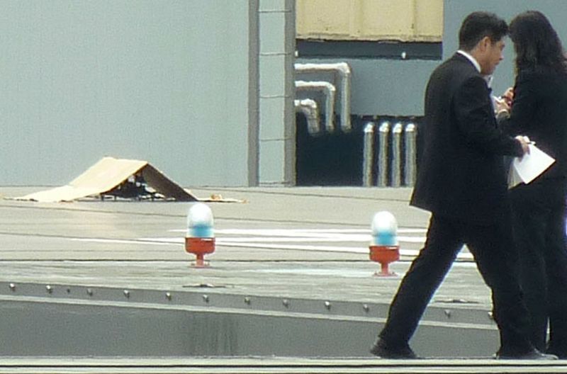 © Reuters. Police and security officers investigate an unidentified drone which was found on the rooftop of Prime Minister Shinzo Abe's official residence in Tokyo