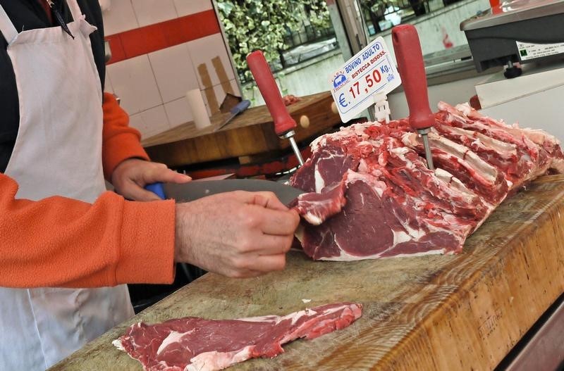 © Reuters. A butcher cuts up beef at a street market in Rome