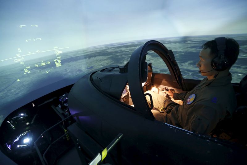 © Reuters. File photo of a pilot demonstrating a simulator of the T-50 advanced jet trainer at the First Fighter Wing of South Korean air force in Gwangju