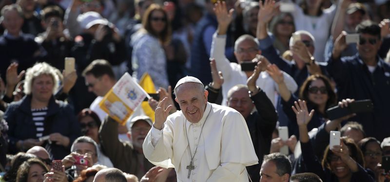© Reuters. Pope Francis waves as he arrives to lead the weekly audience in Saint Peter's Square at the Vatican 