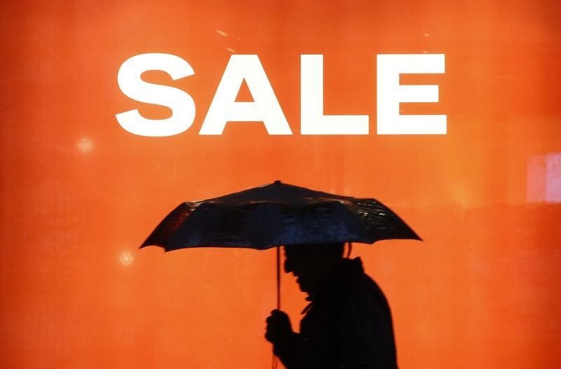 © Reuters. A poster offers sales discounts in a shopping window of a department store in Zurich 