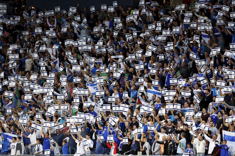 © Reuters. Israel fans hold placards during their Euro 2016 Group B qualifying soccer match against Wales at the Sammy Ofer Stadium in Haifa