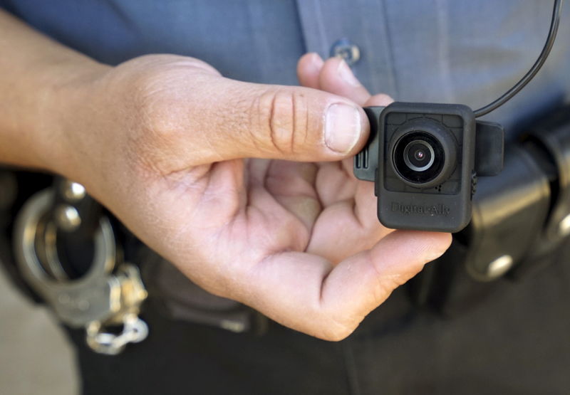 © Reuters. A Colorado Springs police officer poses with a Digital Ally First Vu HD body worn camera outside the police department in Colorado Springs