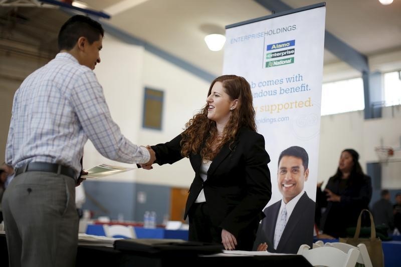 © Reuters. Jessica Kolber shakes hands with a job seeker at a job fair in Burbank, Los Angeles
