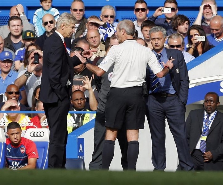 © Reuters. Chelsea manager Mourinho and his Arsenal counterpart Wenger are spoken to by match referee Atkinson during their English Premier League soccer match at Stamford Bridge in London