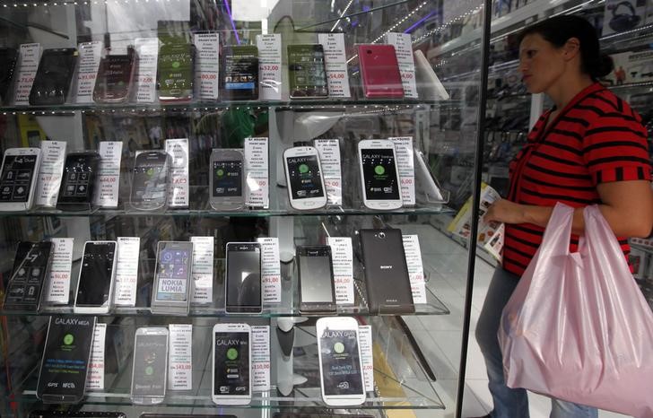 © Reuters. Mulher passa em frente a loja de aparelhos celulares em São Paulo.