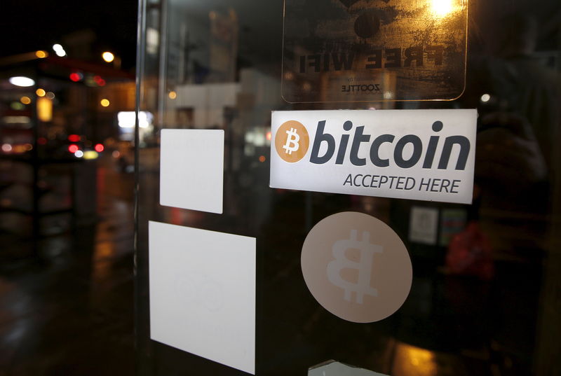 © Reuters. A bitcoin sticker is seen in the window of the 'Vape Lab' cafe, where it is possible to both use and purchase the bitcoin currency, in London