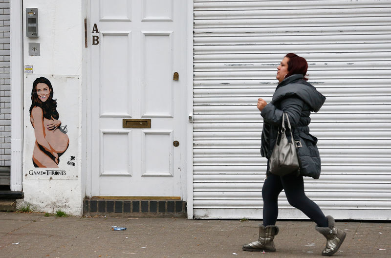 © Reuters. Mulher passa por pintura de princesa Kate grávida em rua de Londres