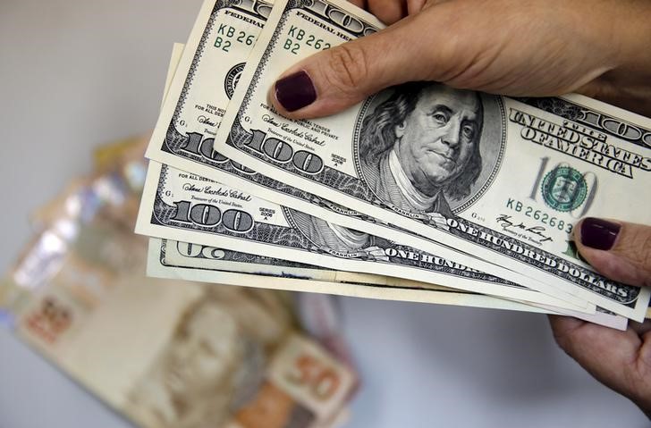 © Reuters. Mulher segura notas de dólar norte-americano no Rio de Janeiro
