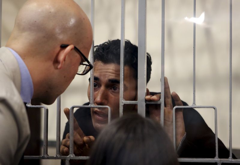 © Reuters. Mohammed Ali Malek speaks with his lawyer Massimo Ferrante at the Catania's tribunal