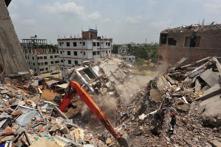 © Reuters. The remaining standing part of the collapsed Rana Plaza building collapses during a rescue operation by the army in Savar