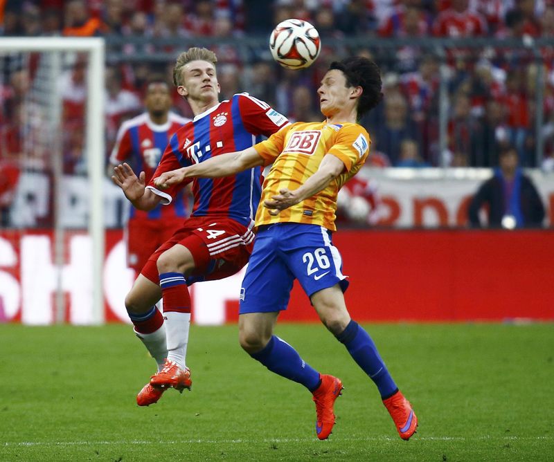 © Reuters. Bayern Munich's Kurt challenges Hertha Berlin's Schulz during Bundesliga first division soccer match in Munich