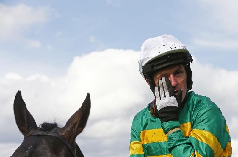 © Reuters. A.P McCoy wipes away a tear after finishing third in the Handicap Hurdle Race, his last ever competitive race