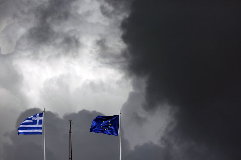© Reuters. A European Union flag and a Greek national flag flutter atop a building in central Athens