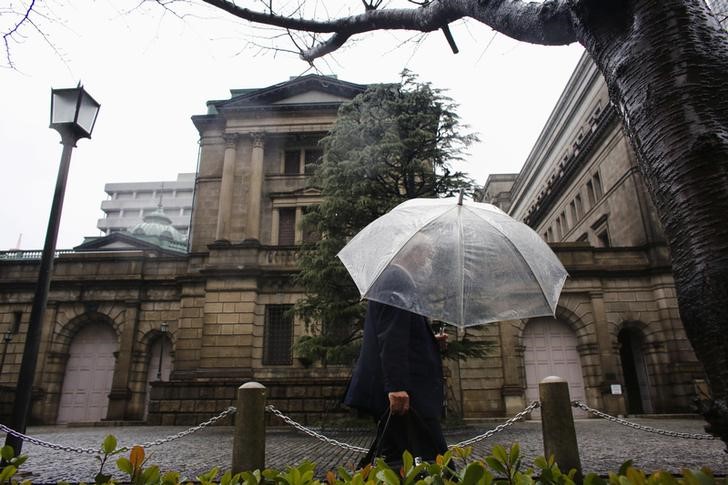© Reuters. A man walks past the Bank of Japan building on a rainy day in Tokyo