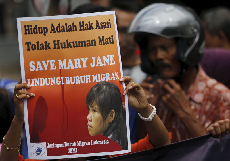 © Reuters. A woman protester holds a placard calling for the life of Mary Jane Veloso, a Filipino facing execution, to be saved during a protest in Cilacap, Central Java province, Indonesia