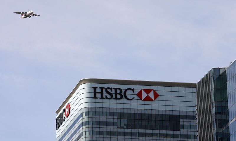 © Reuters. A plane flies past the HSBC building in Canary Wharf
