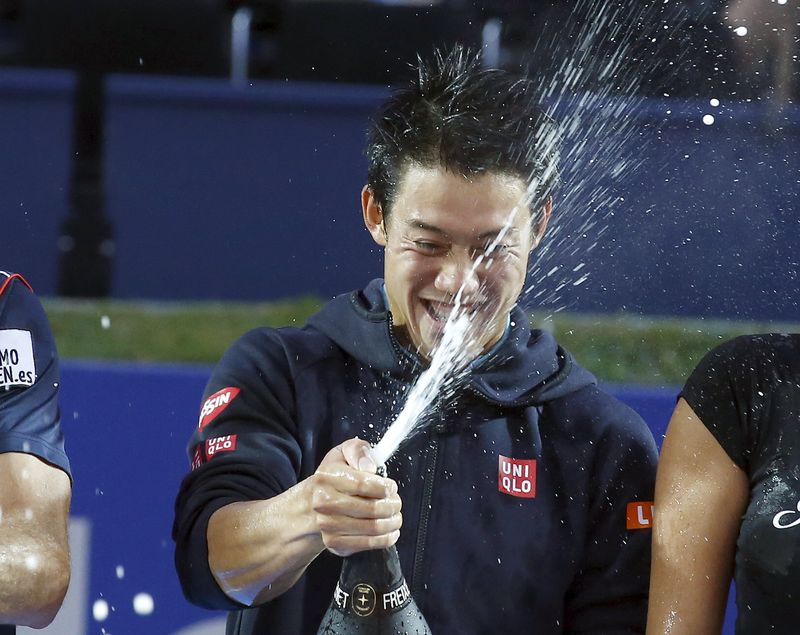 © Reuters. Kei Nishikori of Japan sprays champagne after beating Pablo Andujar of Spain to win the Barcelona Open tennis tournament in Barcelona