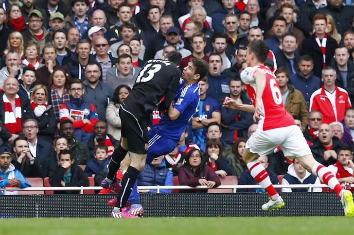 © Reuters. Oscar choca-se contra goleiro do Arsenal em jogo pelo Campeonato Inglês