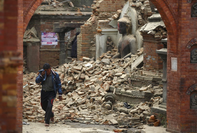 © Reuters. Homem chora em meio a escombros de prédios após terremoto no Nepal