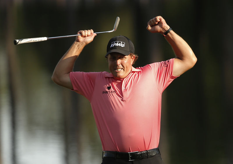 © Reuters. Phil Mickelson of the U.S. celebrates a long birdie putt on the 16th hole during third round play of the Masters golf tournament at the Augusta National Golf Course in Augusta