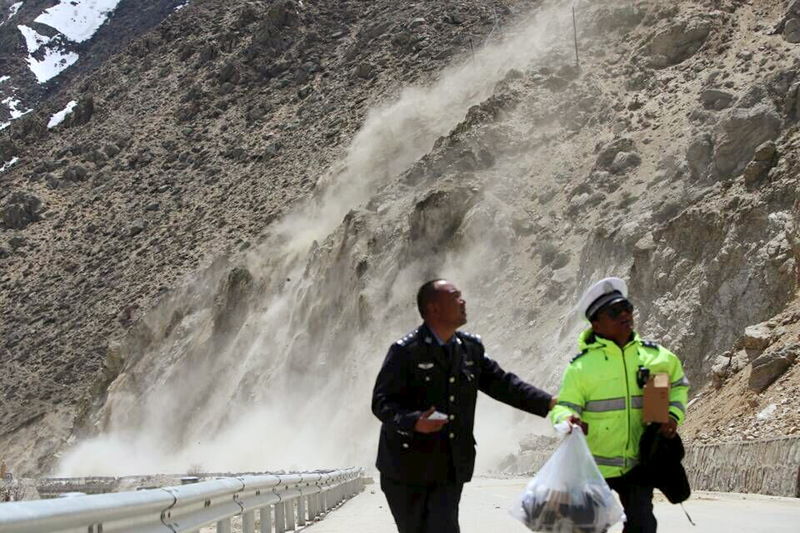 © Reuters. Militares fugindo de um deslizamento por conta do terremoto que atingiu o Nepal no sábado