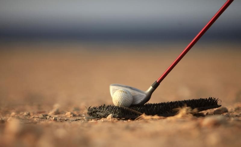 © Reuters. A golf club is positioned near a ball as a boy plays a game near the beach in Gargaresh area in Tripoli