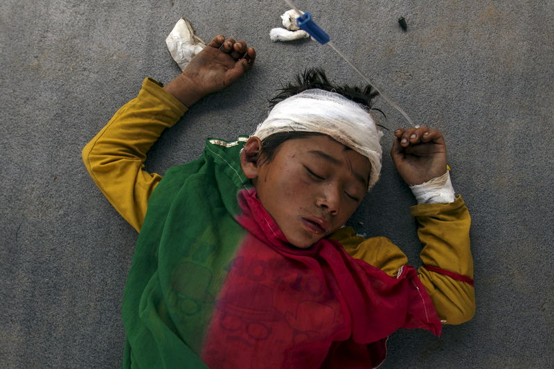 © Reuters. Menino machucado dormindo do lado de fora de um hospital lotado no Nepal