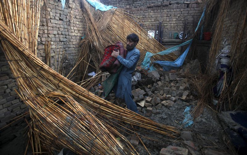 © Reuters. Homem em meio a destroços de sua casa após tempestade, em Peshawar