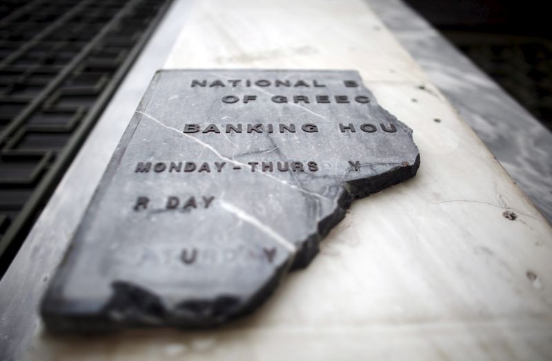 © Reuters. Damaged sign of National Bank of Greece, is seen  at entrance of bank's head office in Athens