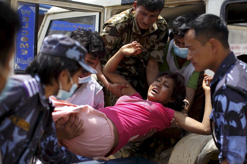 © Reuters. Militares e voluntários carregam uma mulher ferida ao hospital Dhading no Nepal