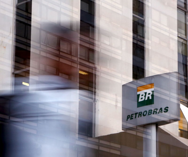 © Reuters. A person walks past the Petrobras logo in front of the company's headquarters in Sao Paulo