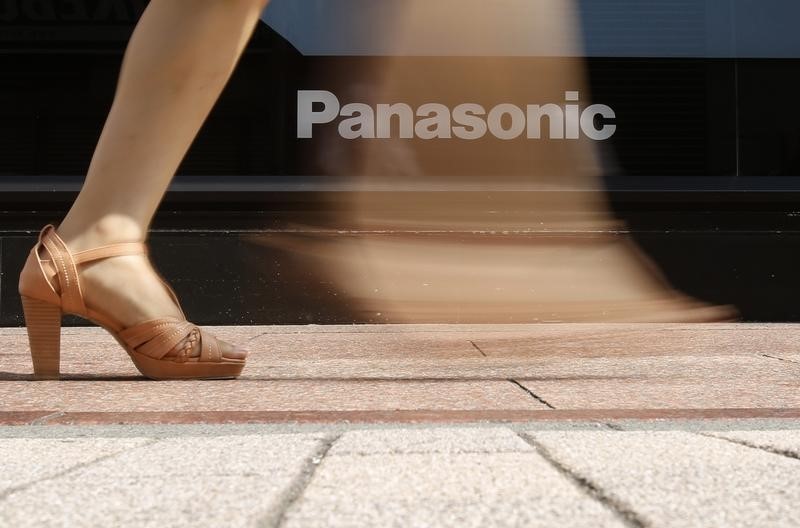 © Reuters. A woman walks past a logo of Panasonic Corp outside an electronics retail store in Tokyo