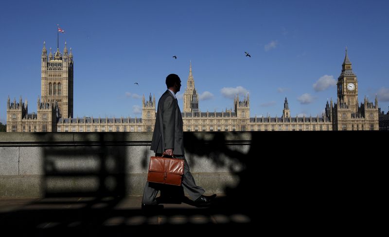 © Reuters. File photo of a man walking past the Houses of Parliament in London